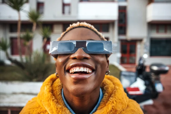 a person wearing eclipse glasses and smiling