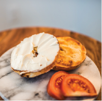 a bagel with cream cheese and some tomato slices