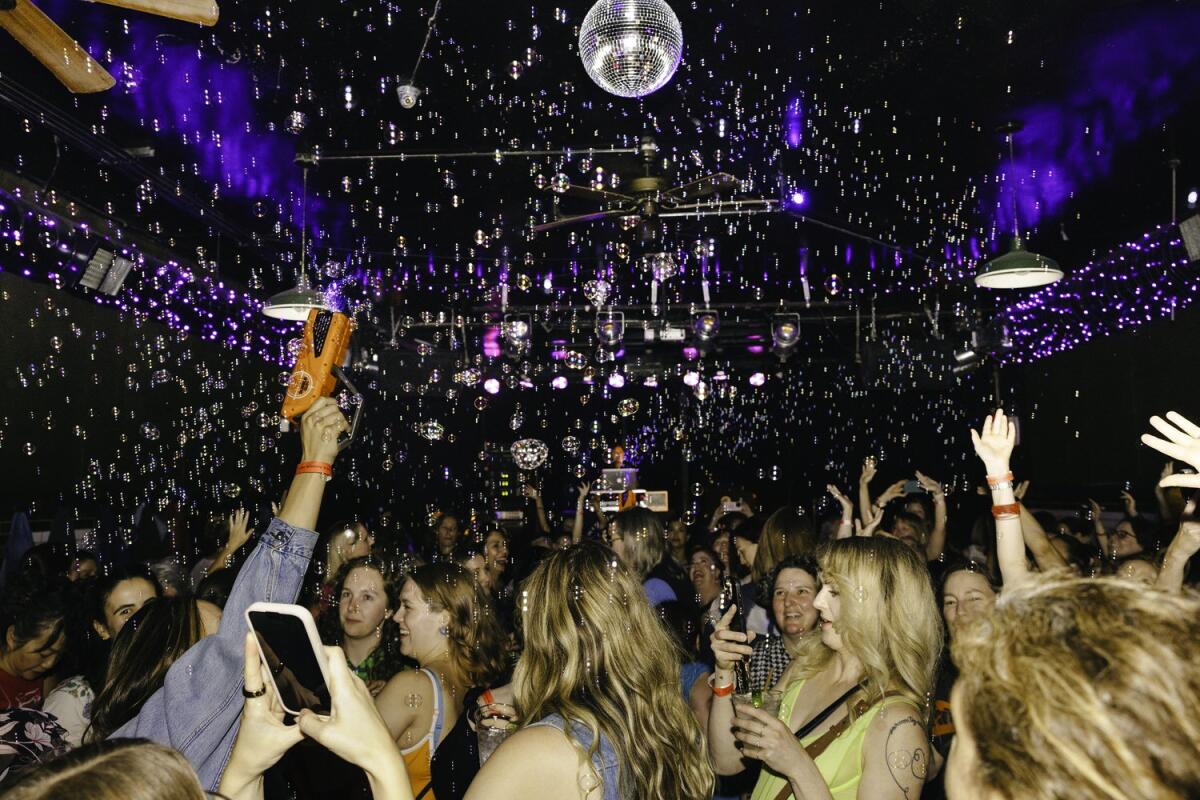 people dancing in dark room under discoball